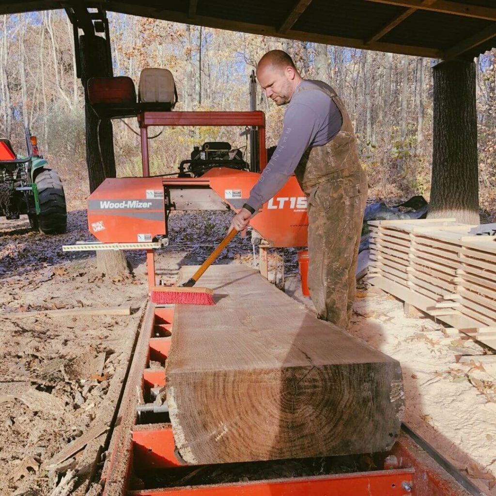 Brushing off planed log after cutting to make into bar for Chicago's Lakeview neighborhood