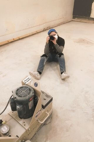 Girl in bandana taking photographs with Nikon camera during renovation of Chicago bar