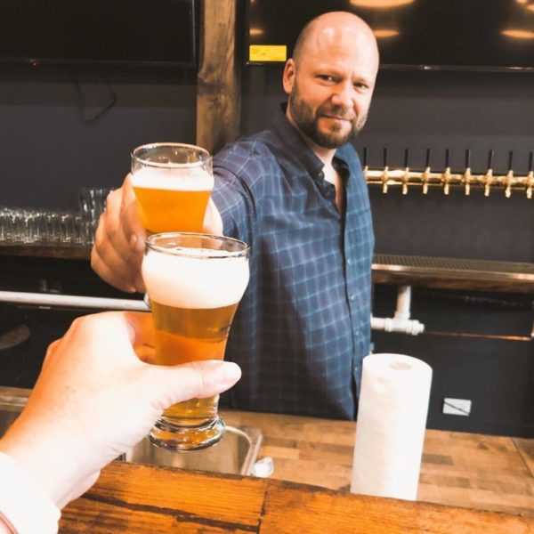 Lakeview Taproom owners toasting with beer before soft opening