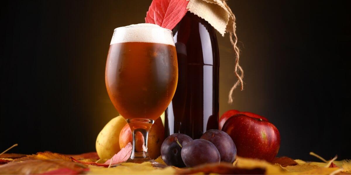A beer surrounded by apples, plums, and fall leaves represents a place to go out in Chicago on Thanksgiving week