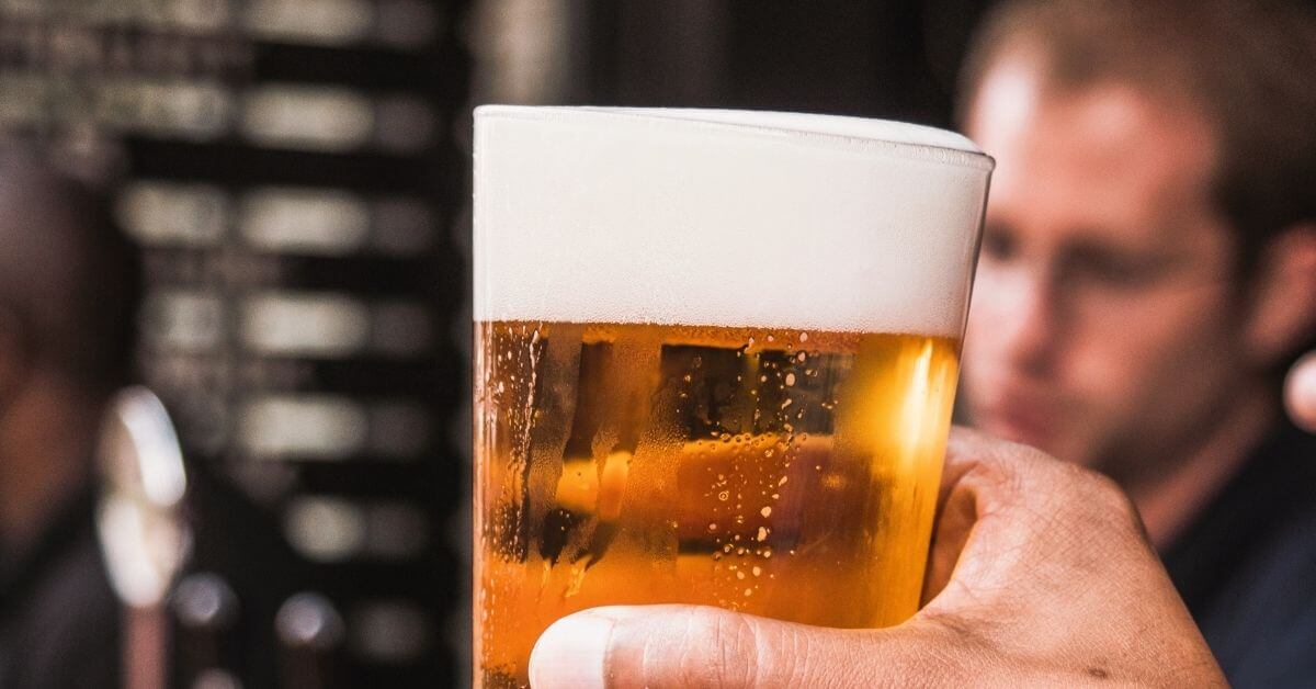 Man holding draft beer in glass at Chicago taproom